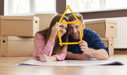 Couple in new apartment with home sign